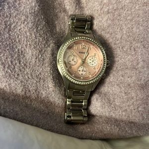 Fossil watch with silver band surrounded by diamonds with pink face